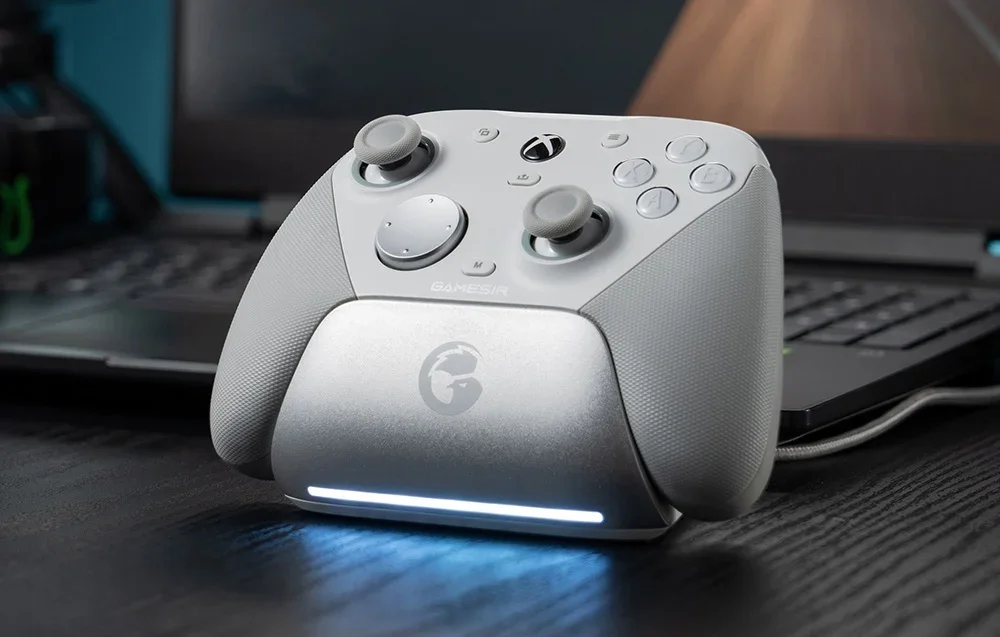 Valge GameSiri kontroller laadimisjaamas sülearvuti ees.