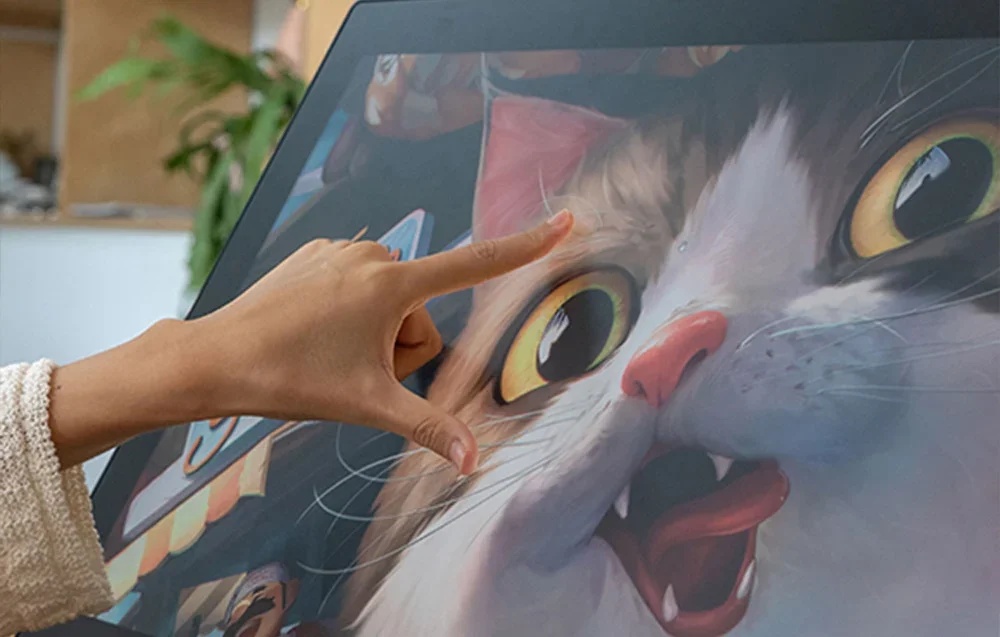 Lähivaates on Huioni graafikatahvel kassi illustratsiooniga, mida sõrmedega suurendatakse.