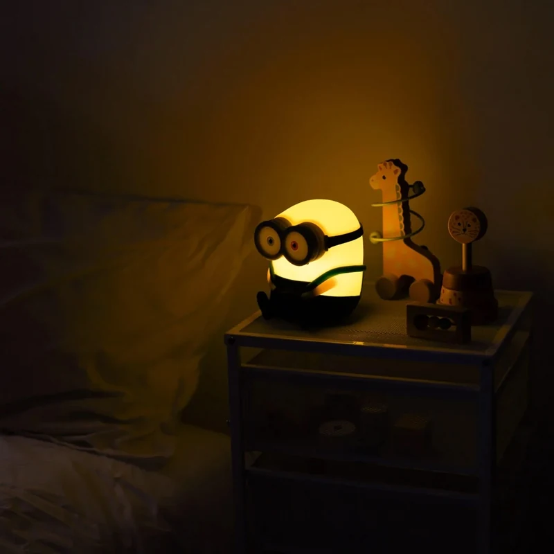 Illuminated Minions Bob lamp on a bedside cabinet in a dim room